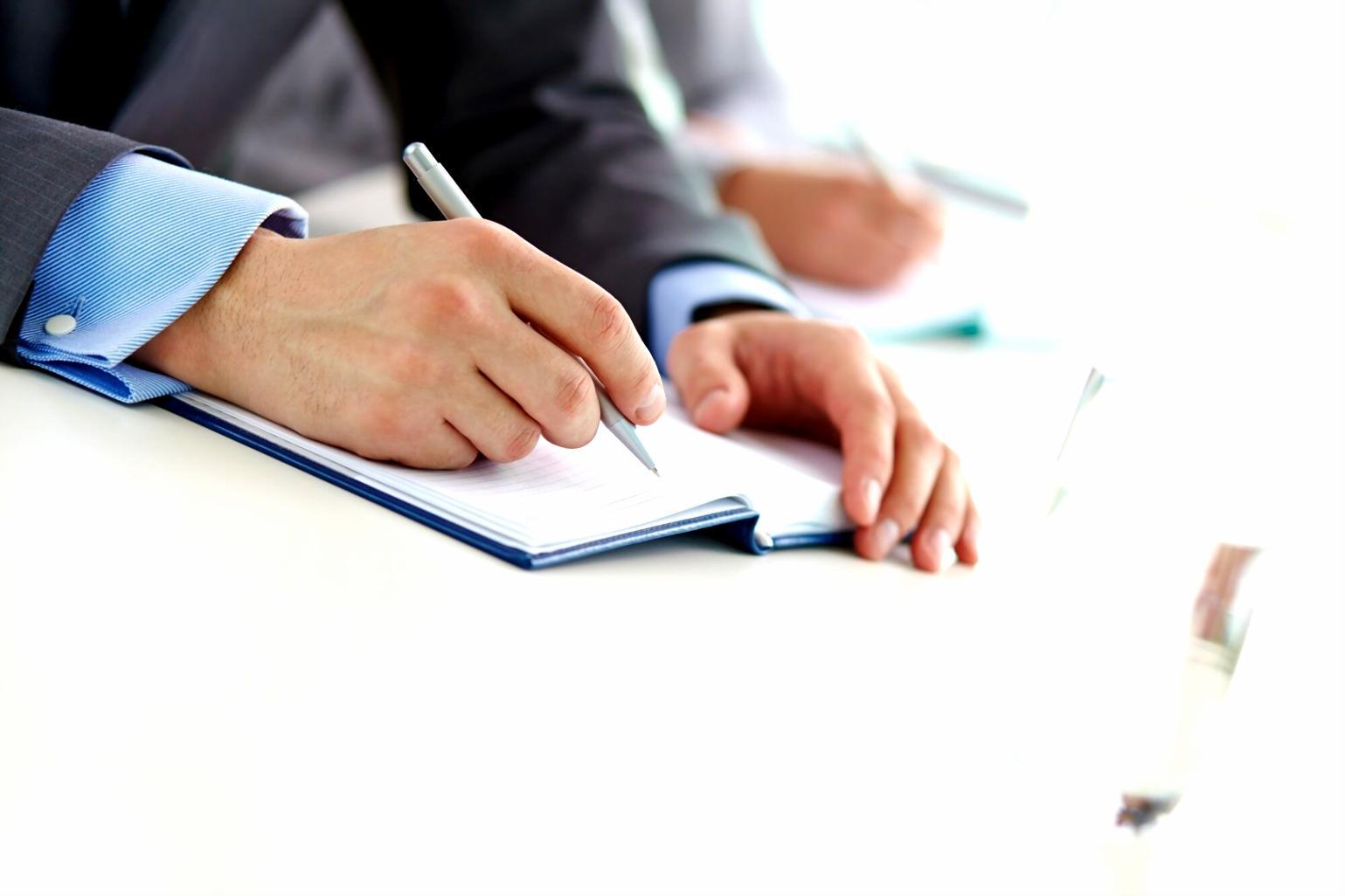 Person arbeitet mit Finanzunterlagen und Laptop